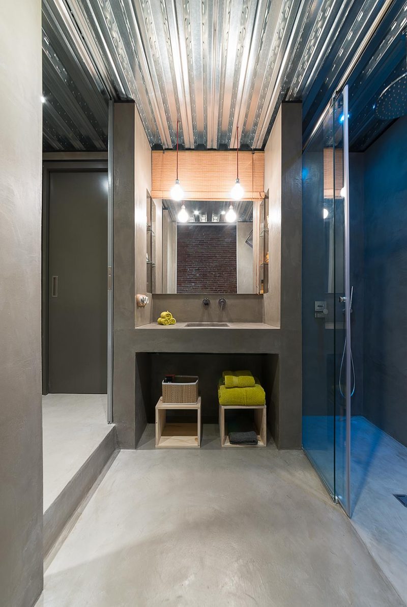 De stoere betonlook gietvloer past perfect in deze industriële badkamer, ontworpen door Studio FFWD.