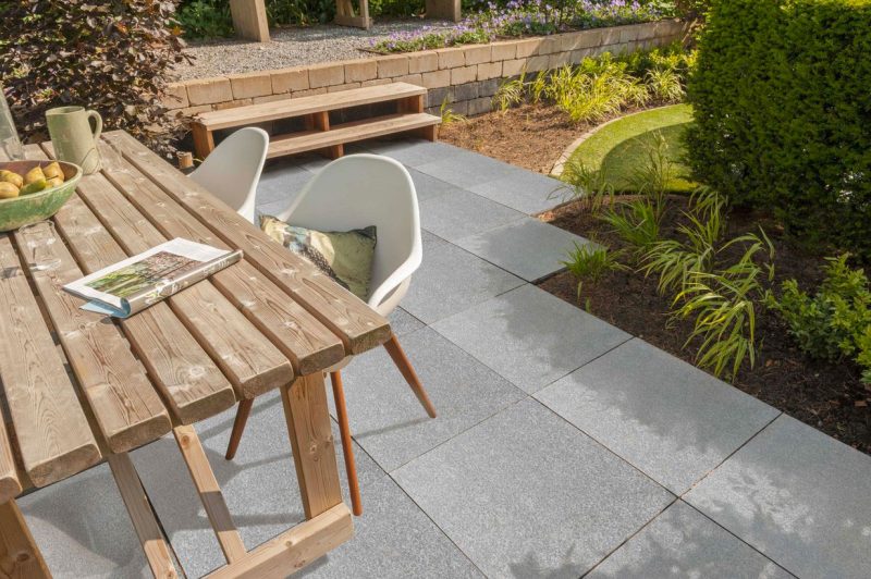 De Kera Twice 60x60x4 cm tegels staan perfect bij de houten meubels in deze tuin.