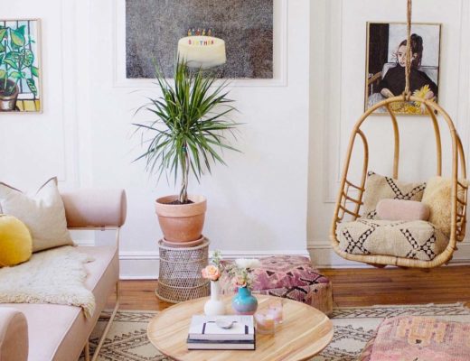 bohemian stijl woonkamer met rotan hangstoel, kleurrijke kussens en planten