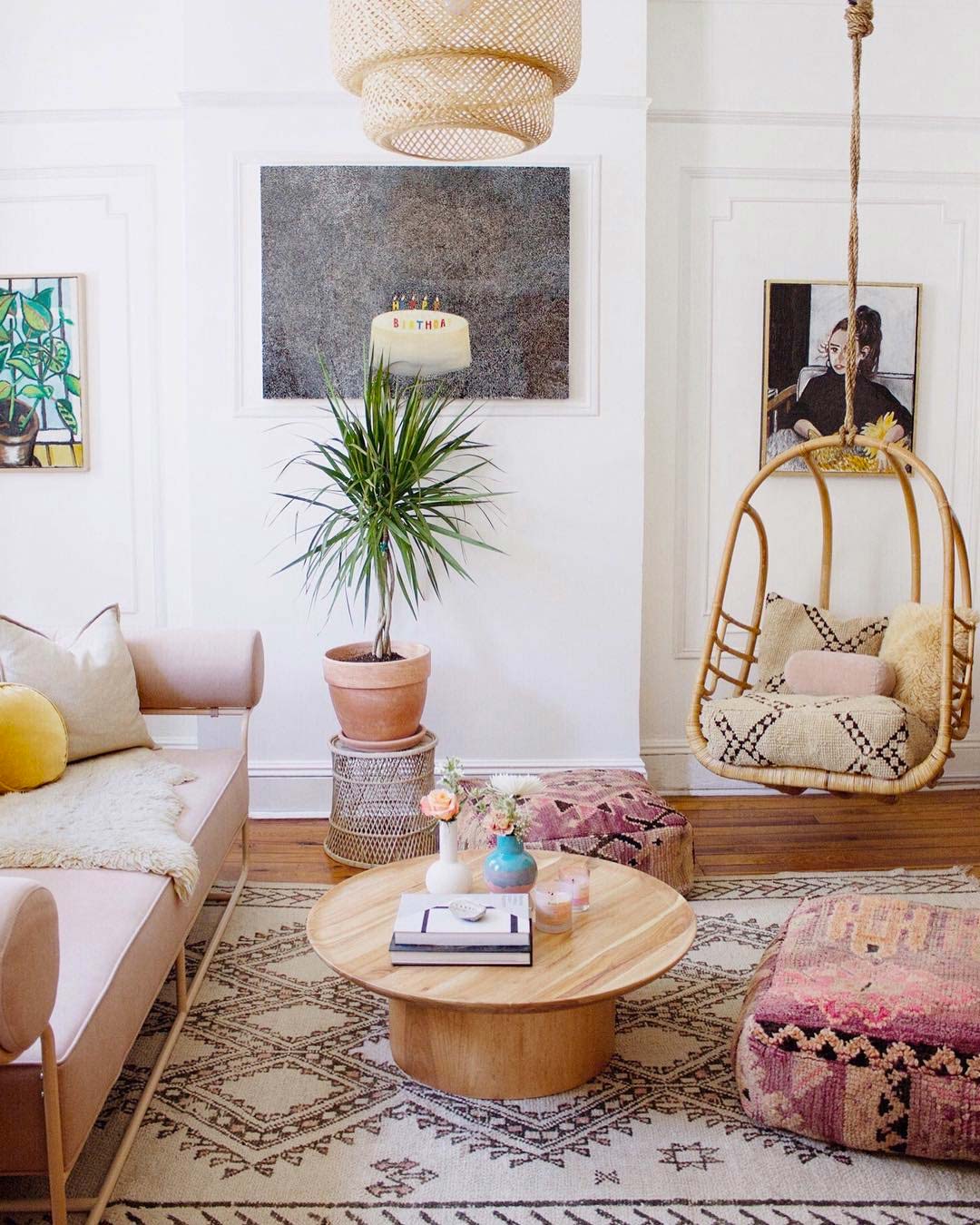 bohemian stijl woonkamer met rotan hangstoel, kleurrijke kussens en planten
