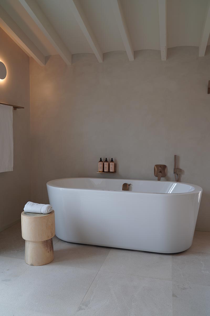 Ook boven het bad kan je douchespullen op een stijlvolle en praktische manier opbergen. In deze stijlvolle badkamer is een mooi plankje boven het bad gemonteerd met leuke flesjes.