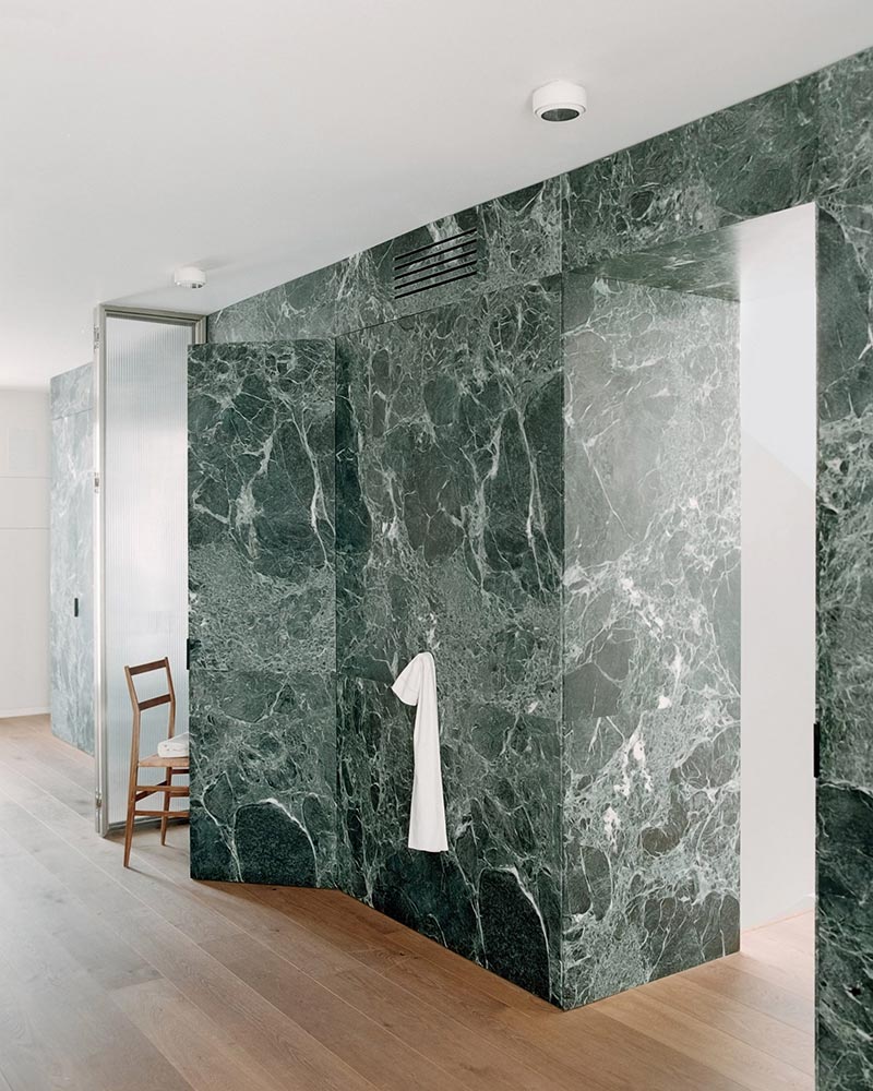 Italiaanse studio AIM heeft in Milaan een chic interieur ontworpen voor een studio met meerdere verdiepingen, georganiseerd rond een kamerhoge Verde Alpi-marmeren scheidingswand. | Fotografie: Simone Bossi