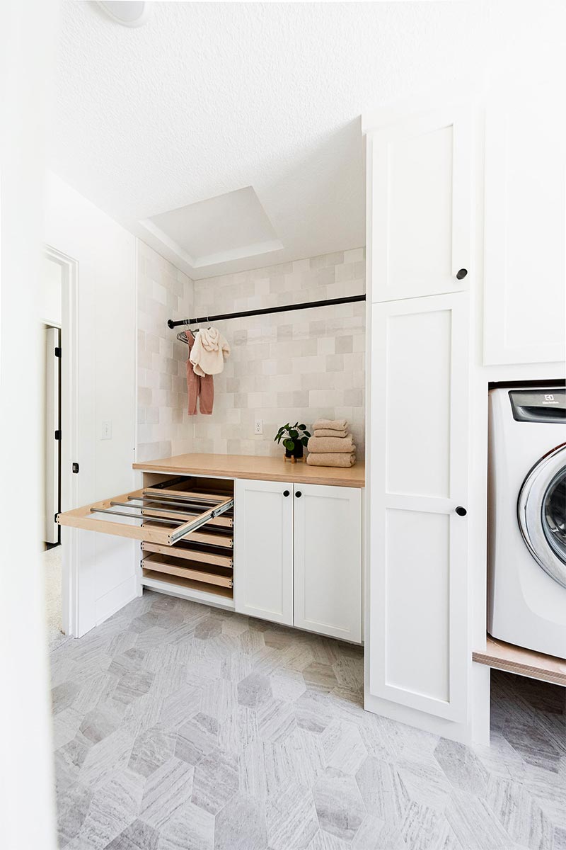 Alma Homes creëerde deze perfecte washok met een gedeelte waar je kleding op verschillende manieren kunt laten drogen. De uitschuifbare droogrekken zijn perfect voor ondergoed en sokken! | Bron: Almahomes.com