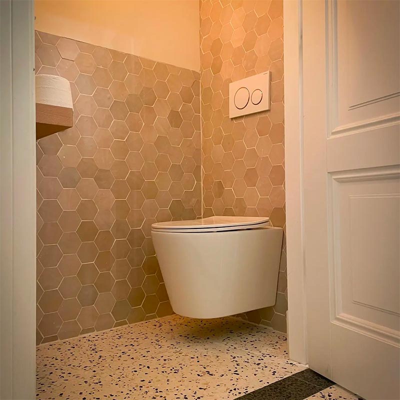 Naomi combineerde leuke marmeren hexagon tegeltjes aan de wand met terazzo vloertegels van Designtegels.nl in haar super leuk toilet!