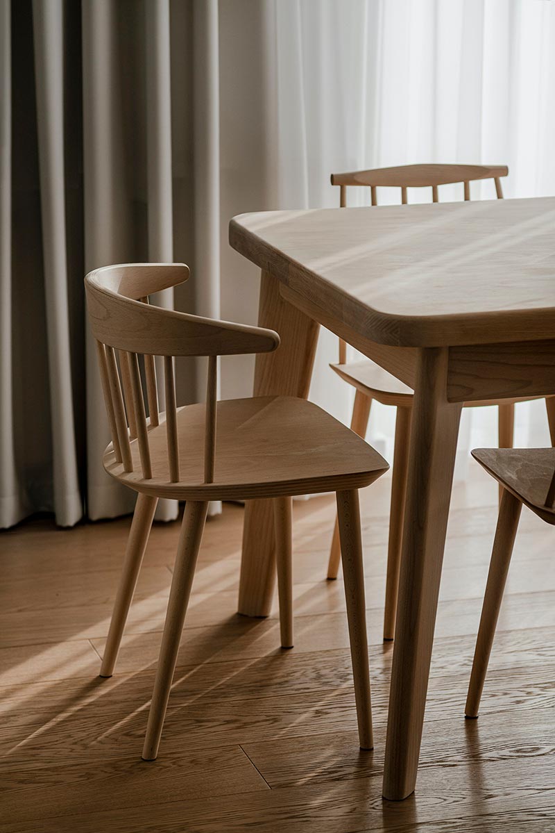 Op maat gemaakte meubels staan naast zorgvuldig geselecteerde stukken van Scandinavische ontwerpers, zoals deze houten eetkamerstoelen van HAY.