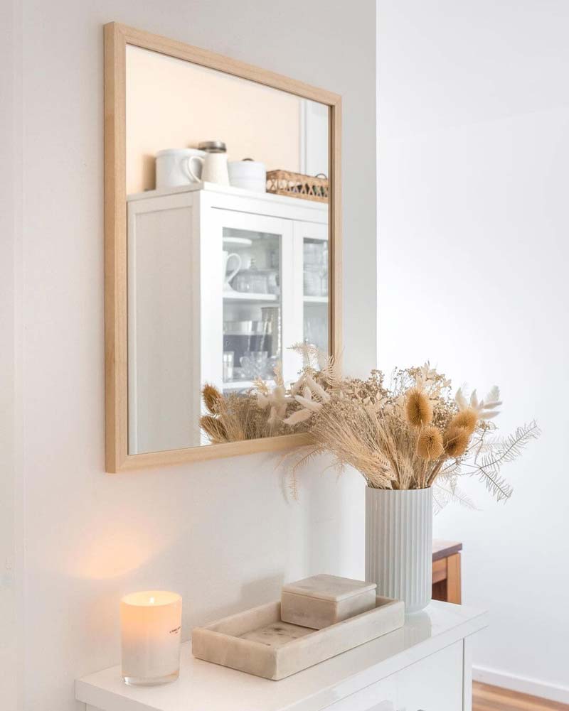 De kleine houten spiegel staat perfect bij de muurkleur en de kast.
