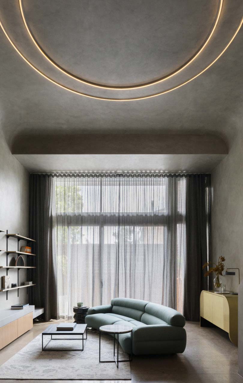 In deze stoere woonkamer met betonlook wanden en plafond, heeft interieurontwerper Matt Woods gekozen voor een hele bijzondere wandlamp.