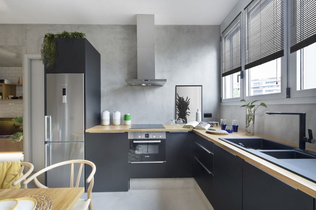 Studio Egue Y Set heeft gekozen voor betonstuc muren voor vrijwel alle muren in een klein appartement uit Barcelona. Zo hebben ze ook gekozen voor een stoere grijze betonstuc keukenachterwand.