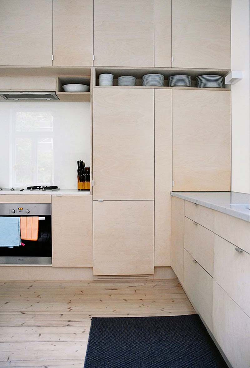 In deze stoere keuken hebben ze underlayment kasten gecombineerd met een moderne plexiglas keukenachterwand.