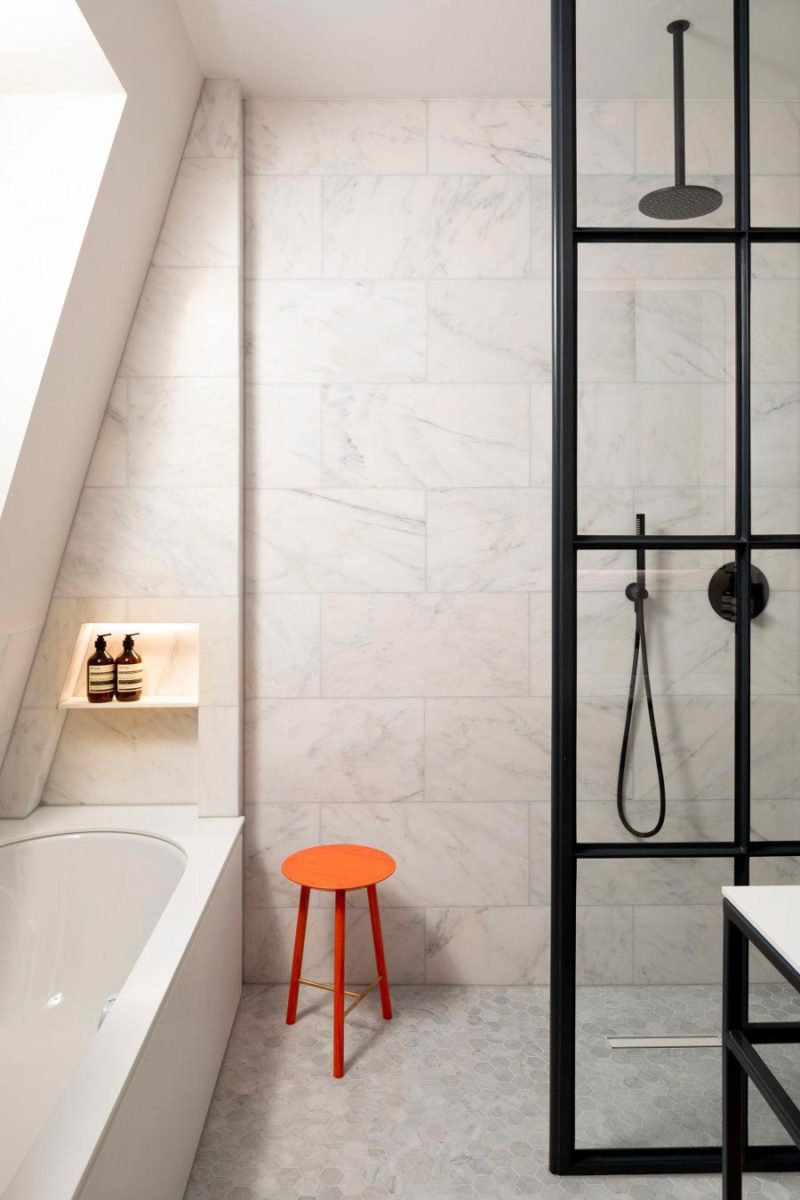 Fraher Architects combineerde een regendouche in het plafond met een bijpassende handdouche in deze badkamer.