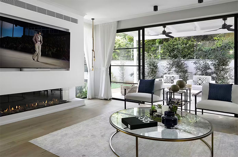 Een luxe cinewall met elektrische sfeerhaard in een luxe woonkamer, ontworpen door Karen Maimon