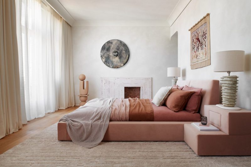 Een enorm roze fluwelen bed is het middelpunt van de comfortabele luxe slaapkamer.
