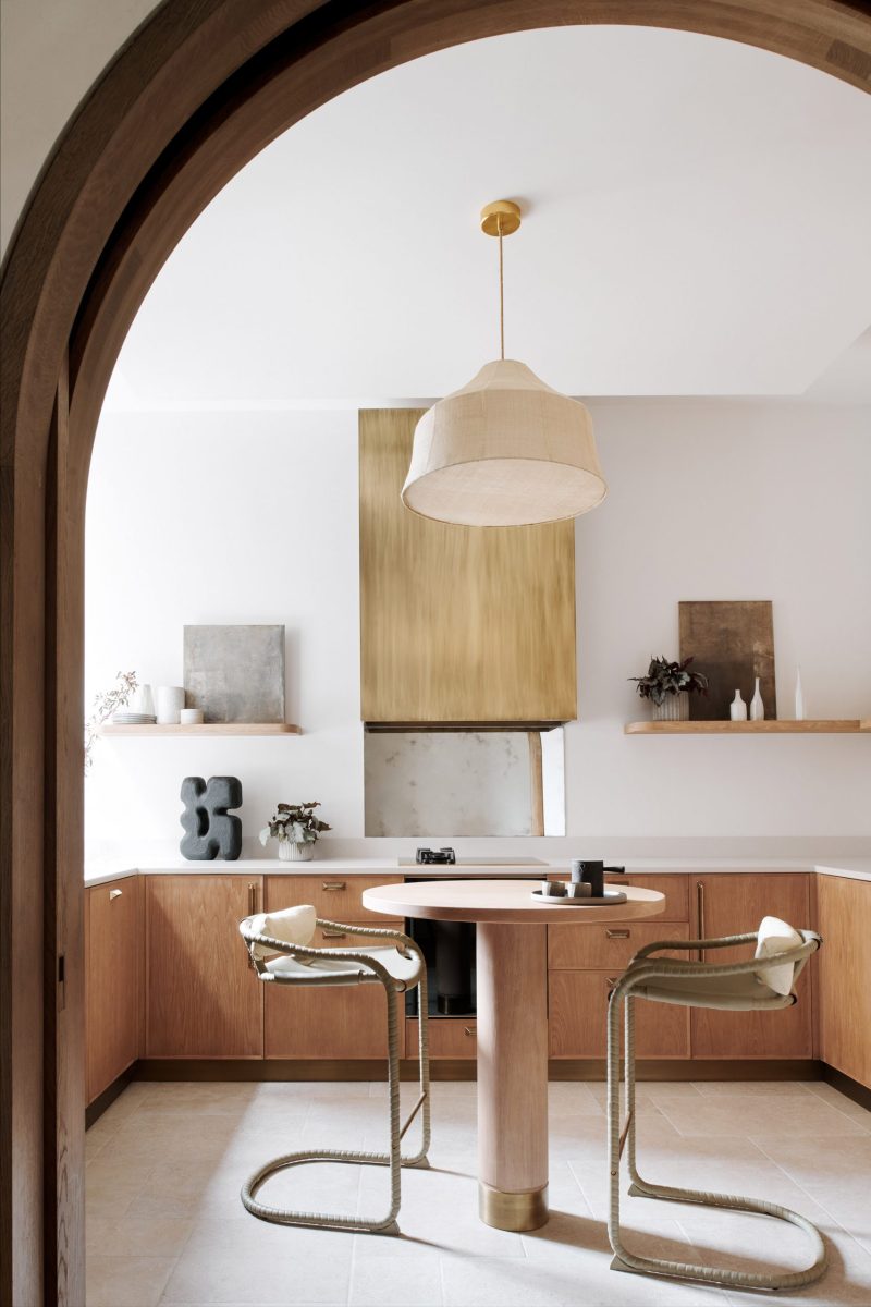 Houten kasten contrasteren met koperen details in de vintage keuken.