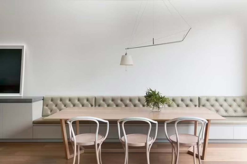 Dit moderne interieur is ontworpen door Robson Rak Architects, die gekozen, die heeft gekozen voor een grote eetbank op maat met 'chesterfield' look rugkussens, gecombineerd met een houten eettafel en houten eetkamerstoelen. | Fotografie: Shannon McGrath
