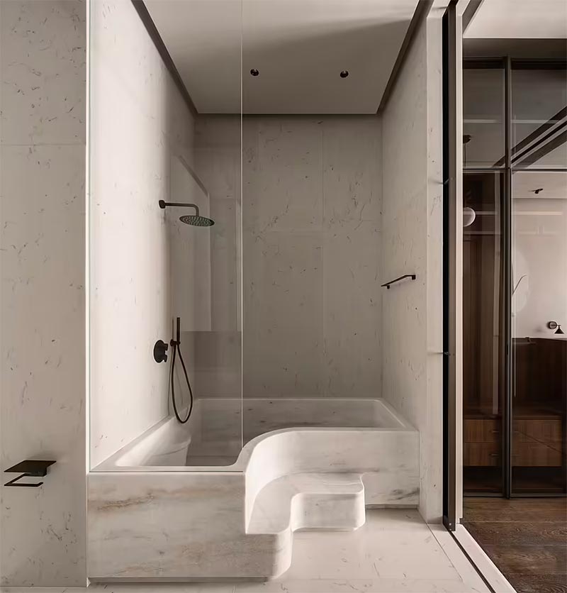 Yatofu Creatives heeft deze luxe badkamer ontworpen, waar de muren bekleed zijn met mooie lichte marmeren wandtegels. | Fotografie: Yatofu Creatives