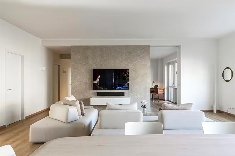 De marmeren accentmuur vormt een ware blikvanger in deze luxe woonkamer, ontworpen door Quarta & Armando. | Fotografie: Beppe Giardino