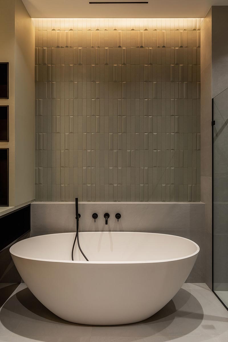 modern vrijstaand bad bij mooi betegelde muur