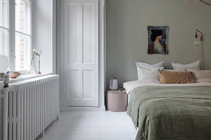 In deze fijne slaapkamer zijn verschillende gedempte kleuren met elkaar gecombineerd, met onder andere nude, groen en grijs.