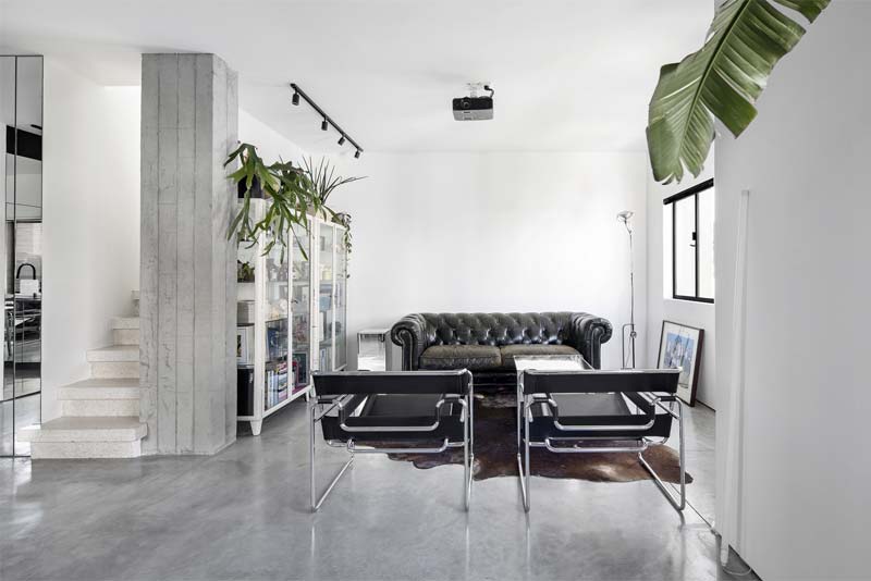 In het door interieurontwerper Yael Perry ontworpen Mirror Maze Apartment, wordt de minimalistische zwarte railverlichting als accentverlichting op de vitrinekasten gebruikt.