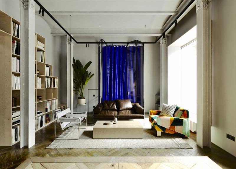 In de super mooie woonkamer, ontworpen door unnamed studio, hangt de zwarte railverlichting met kabels onder het plafond.