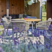 In deze smalle diepe tuin is een overdekte loungehoek ingericht, terwijl de eettafel in het zonnige gedeelte staat