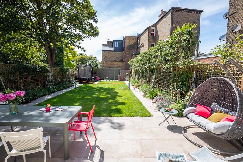 In deze familietuin, ontworpen door Garden Builders, vind je twee praktische tuinpaden van prachtige stenen langs de randen van de tuin. | Bron: Gardenbuilders.co.uk