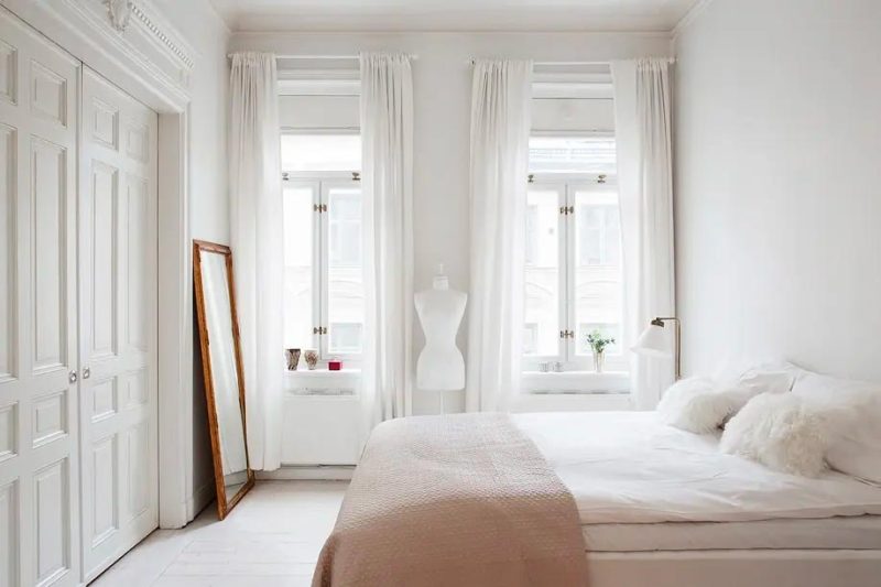 Een bedsprei in nude kleurtint kan heel veel doen in een witte slaapkamer.