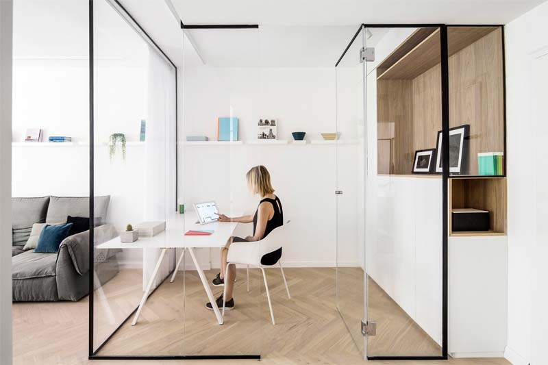 Architect Amir Navon van Studio 6b Design School en interieur ontwerper Maayan Zusman hebben in deze woonkamer een thuiskantoor ingericht met glazen wanden en glazen deur.