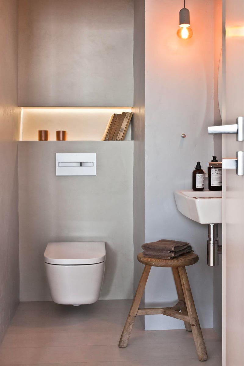 Ontwerper Agnieszka Karaś heeft voor dit toilet gekozen voor beton ciré vloer en wanden, wat resulteert in een minimalistisch, modern en vooral praktisch ontwerp.