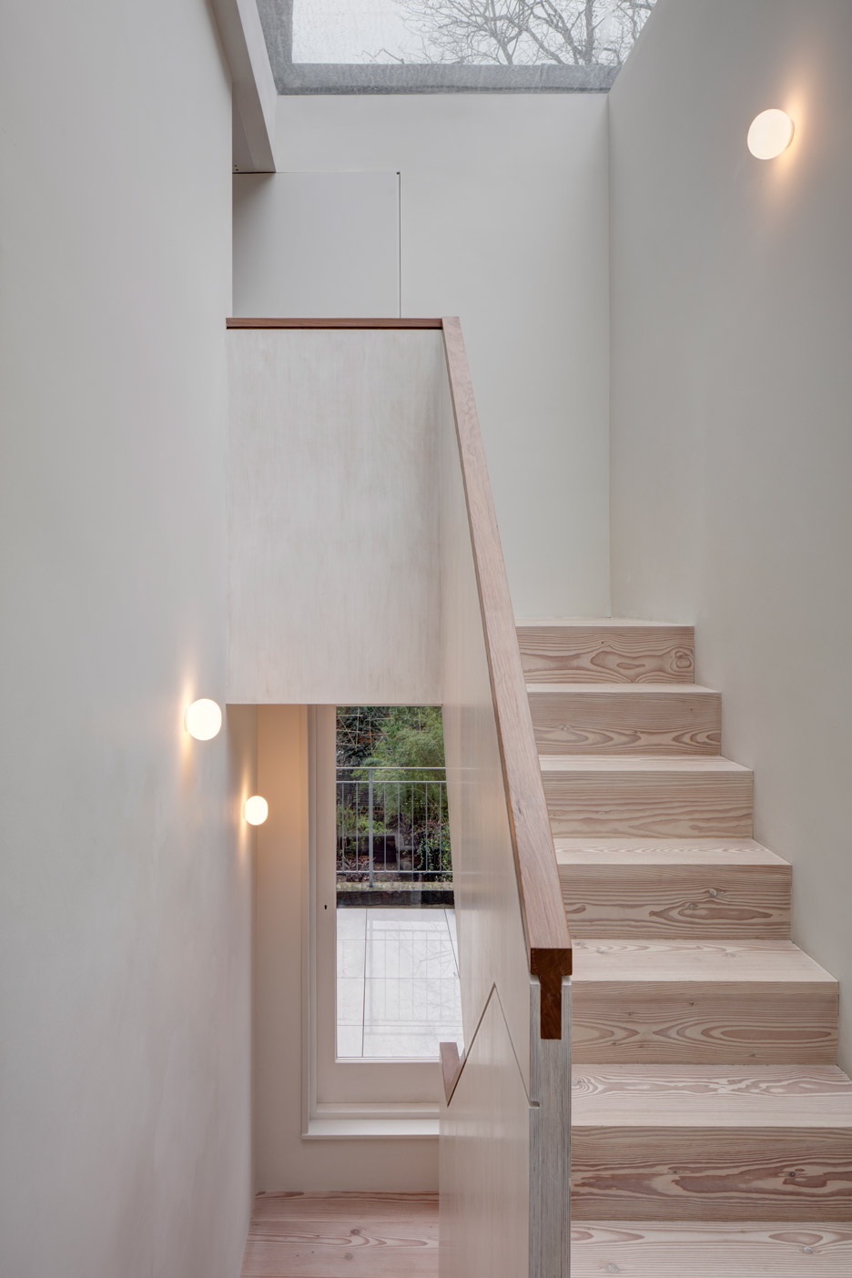 Architecture studio APA heeft een super mooi ontwerp gerealiseerd voor een woning in Londen. De douglashouten trap is gecombineerd met strakke witte muren, die gedecoreerd zijn met prachtige bol wandlampen. | Fotografie: Ed Reeve