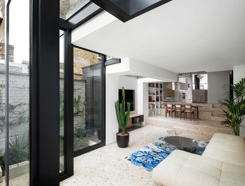trapvormige glazen uitbouw splitlevel woonkamer keuken