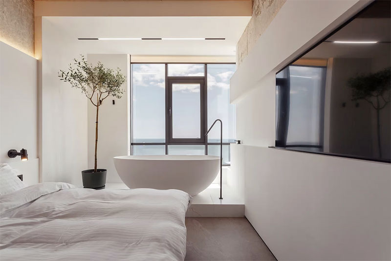 Kernproject voor Sea&Sky Apartment Hotel is een modern appartement in Odessa, Oekraïne, ontworpen in 2021 door Scapes Concept Studio. Bij het raam is een modern ovaal vrijstaand bad geplaatst.