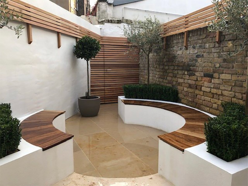 Living Gardens heeft deze leuke tuin ontworpen, waar een onbewerkte bakstenen muur gecombineerd is met een witte bakstenen muur. | Bron: Living-gardens.co.uk
