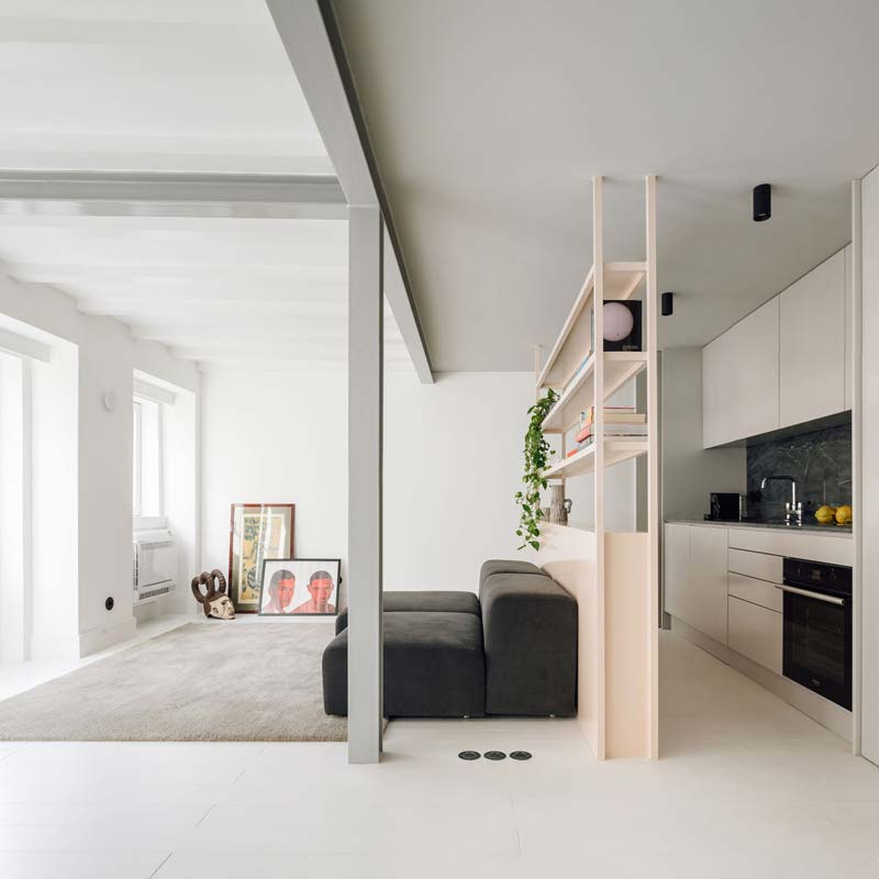 In deze minimalistische moderne woonkamer is de grote kale muur gedecoreerd met een verticale en een horizontale lijst op de vloer. Klik hier voor meer foto's.