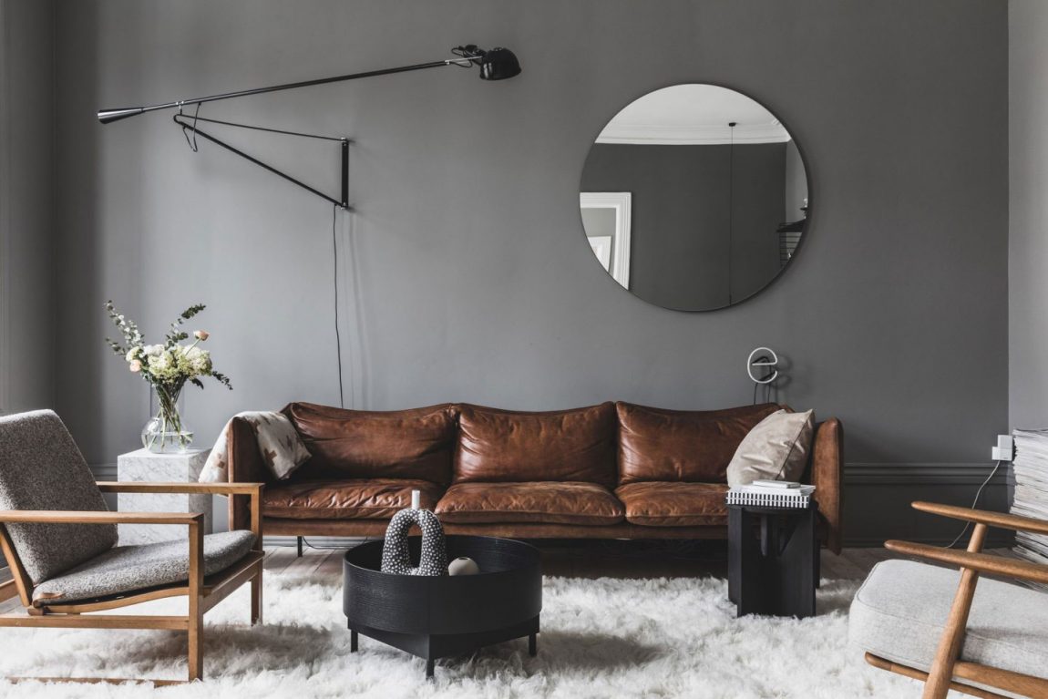 Noorse interieurarchitect Cathrine van ontwerpstudio Heem heeft een mooie grote ronde spiegel aan de grijze woonkamer muur opgehangen. Klik hier voor meer foto's.