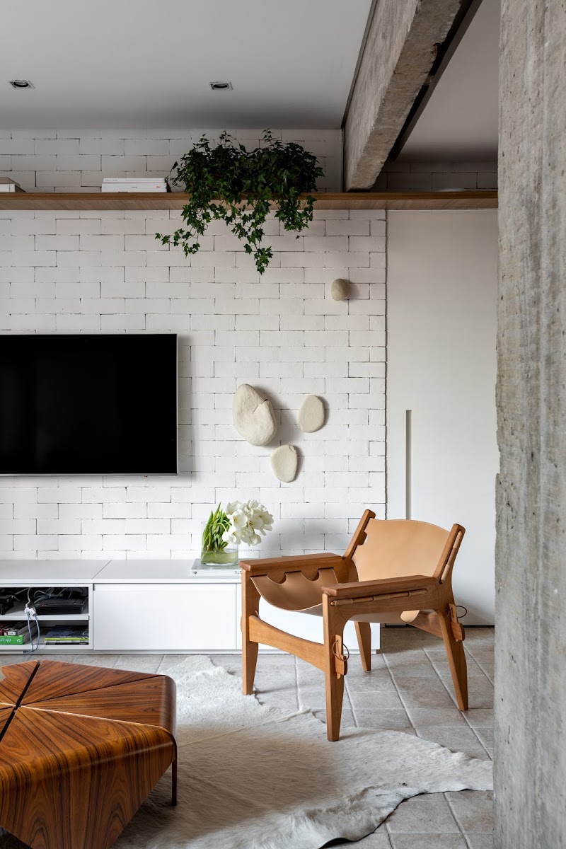 In deze stoere woonkamer is een houten wandplank boven de TV gemonteerd, waar onder andere mooie hangplanten op zijn geplaatst. Klik hier voor meer foto's.