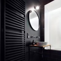 zwarte designradiator aan zwarte wand badkamer