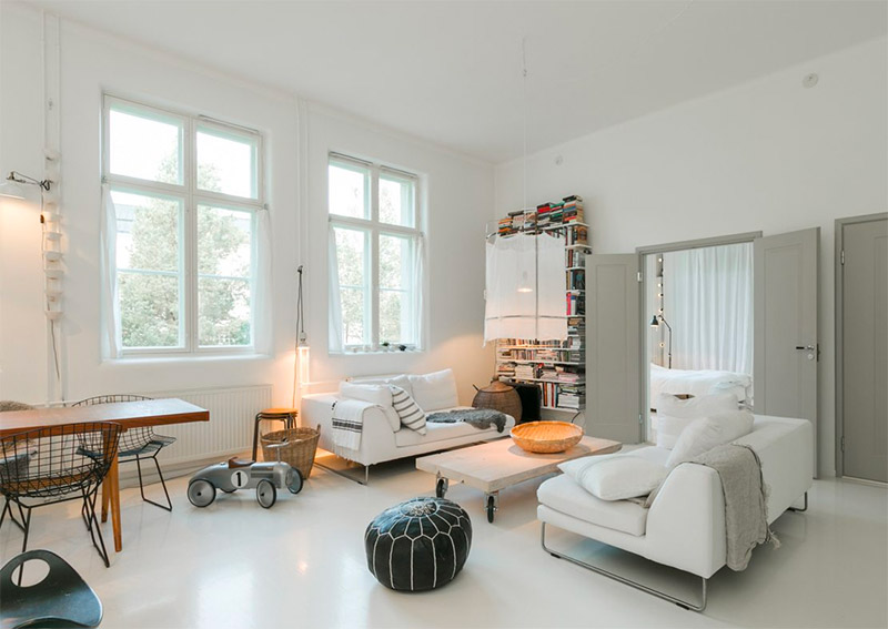 In deze moderne witte woonkamer zorgt de zwarte Marokkaanse poef voor een mooi contrast.